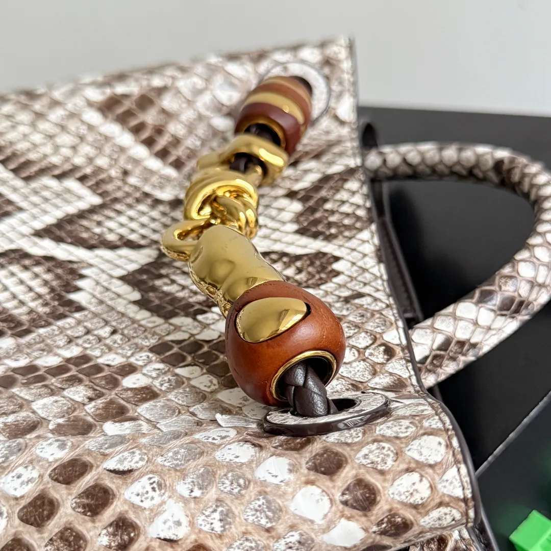 The new Andiamo batch of 3060 BV is shipped‼ ️The classic intercciato weaving process is used to create a soft bag, the metal knot is made of micro-cast aluminum using jewelry technology🪢, and the decorative beads are made of metal and hand-polished oak, allowing you to jump repeatedly between elegance and fun💃, making it unpredictable. Classic and versatile, it shows off your temperament, and the bag has a large capacity, making it very convenient for daily commuting! It has a variety of carrying methods, the shoulder straps can be adjusted by yourself, the original lambskin feels soft and delicate, and the unisex style breaks gender boundaries and brings a more practical and long-lasting use experience. The Andiamo, which has both elegant and casual styles, perfectly interprets the "fashionable old money style". Style number: 743568+wood hardware Color: original snakeskin pattern Size: 25*22*10.5cm